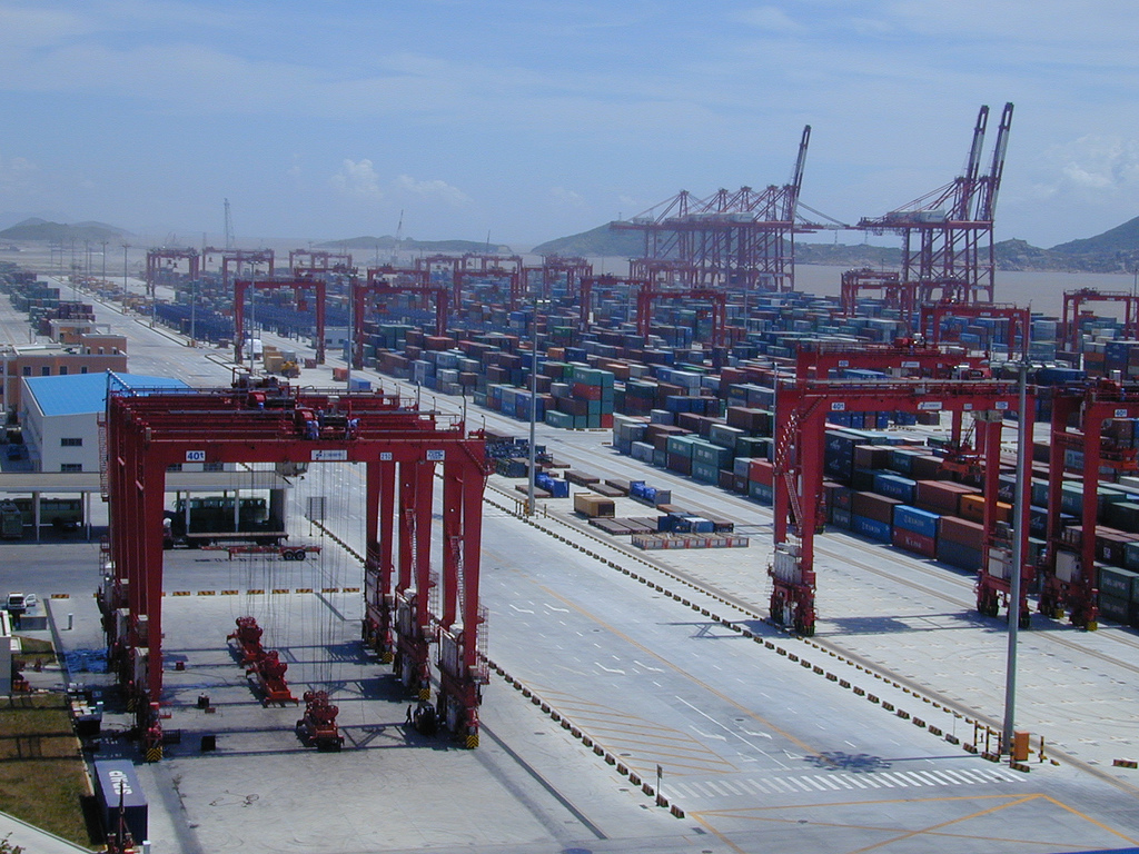 Containerterminal und rote Kräne am Tiefwasserhafen Yangshan in Shanghai, China